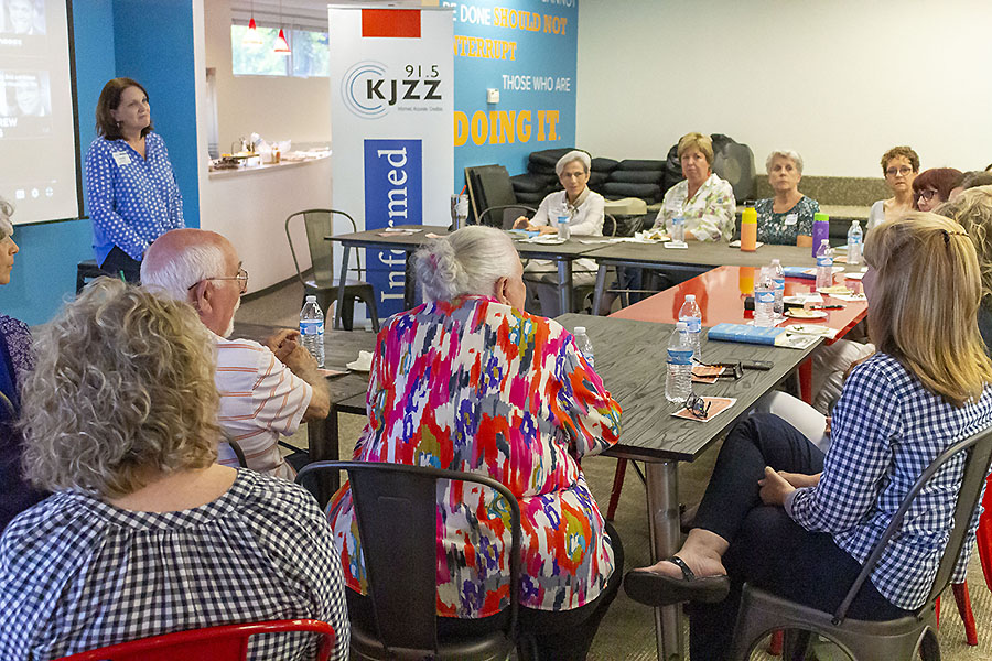 KJZZ and KBACH members sit around tables and discuss the book Moment of Lift