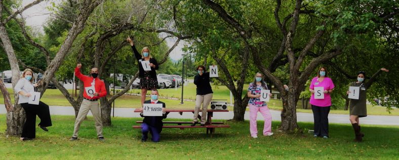 "Join Us" spelled out by people holding signs.