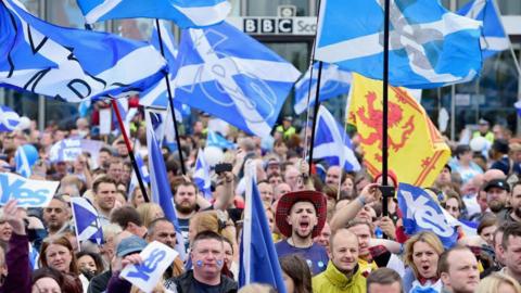 hundreds of marchers holding up Yes Scotland flags