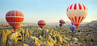 Heißluftballons über den Feenkaminen Kappadokiens – die Tuffsteinformationen im Göreme-Nationalpark gehören zum UNESCO-Weltkulturerbe.
