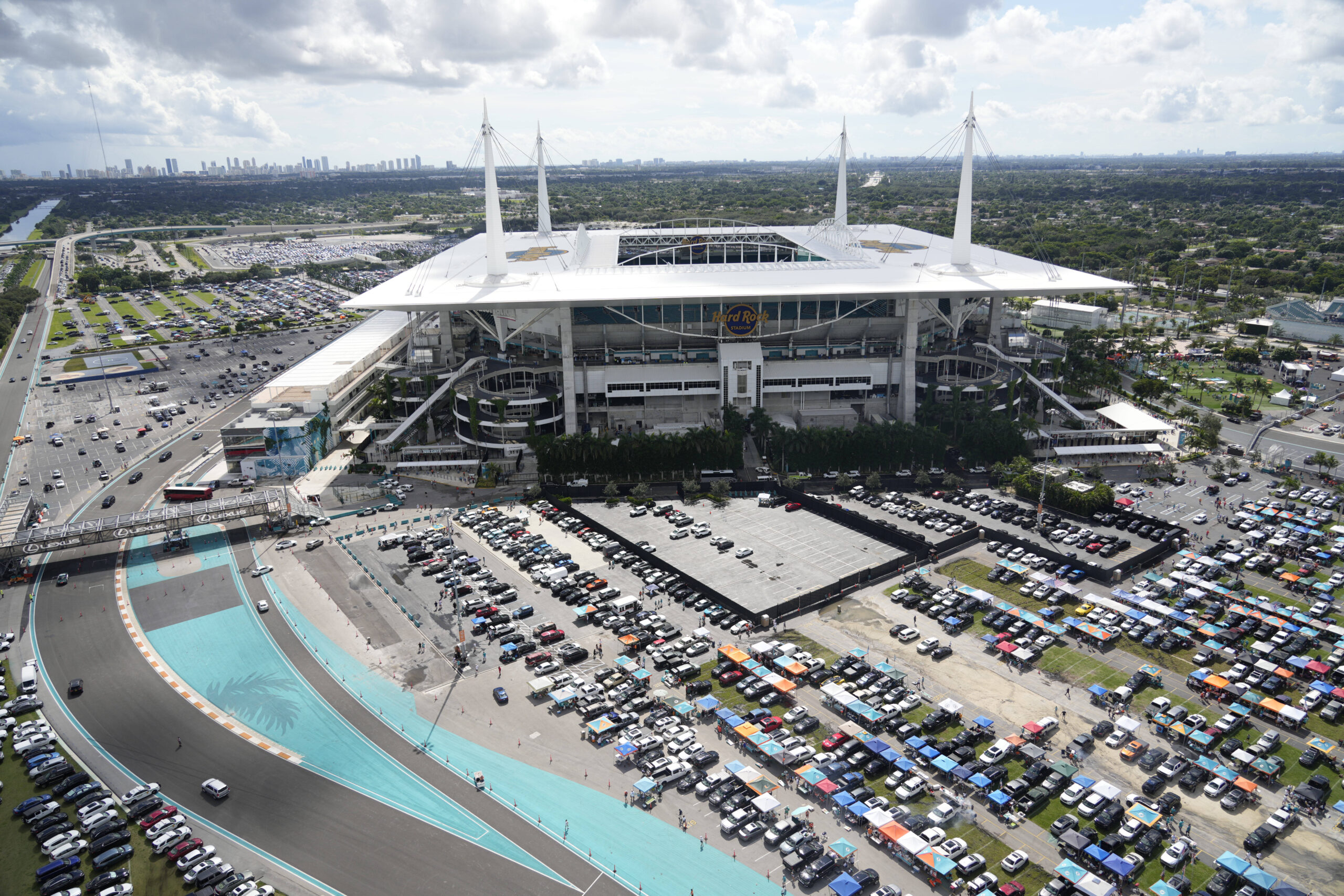 Broncos Dolphins Football Aerial image of Hard Rock Stadium on a game day with full tailgate lots, shining sun and the Sunny Isles skyline in the background.